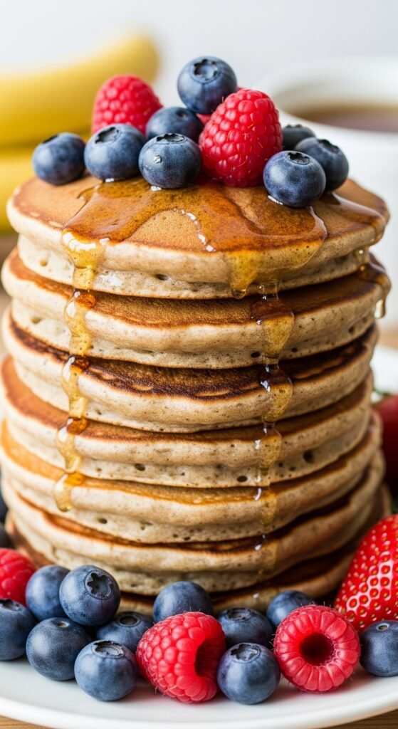 Healthy pancakes pile on a plate with berries syrup